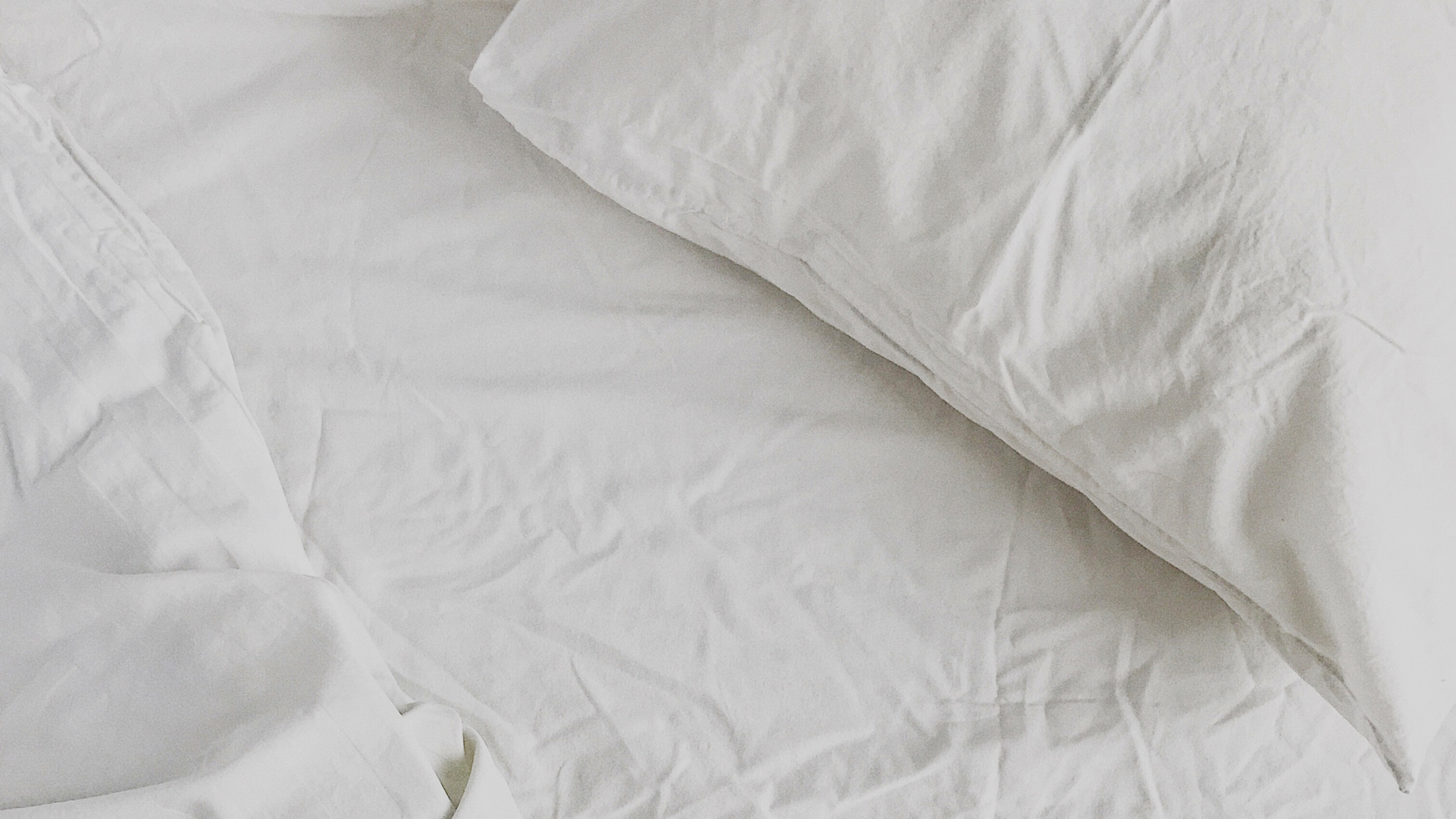picture of white linen bed for organic traditions blog post 5 Foods To Stop Eating Before Bed + 5 To Start
