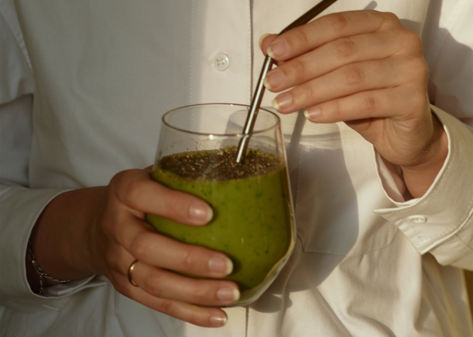 A person holding green superfood drink 